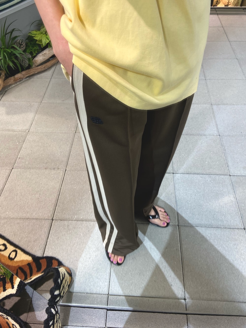 イエロー系のTシャツ/カットソー、ブラウン系のその他パンツ、ブラック系のサンダルを着用したレディースの春コーディネートの3枚目の写真