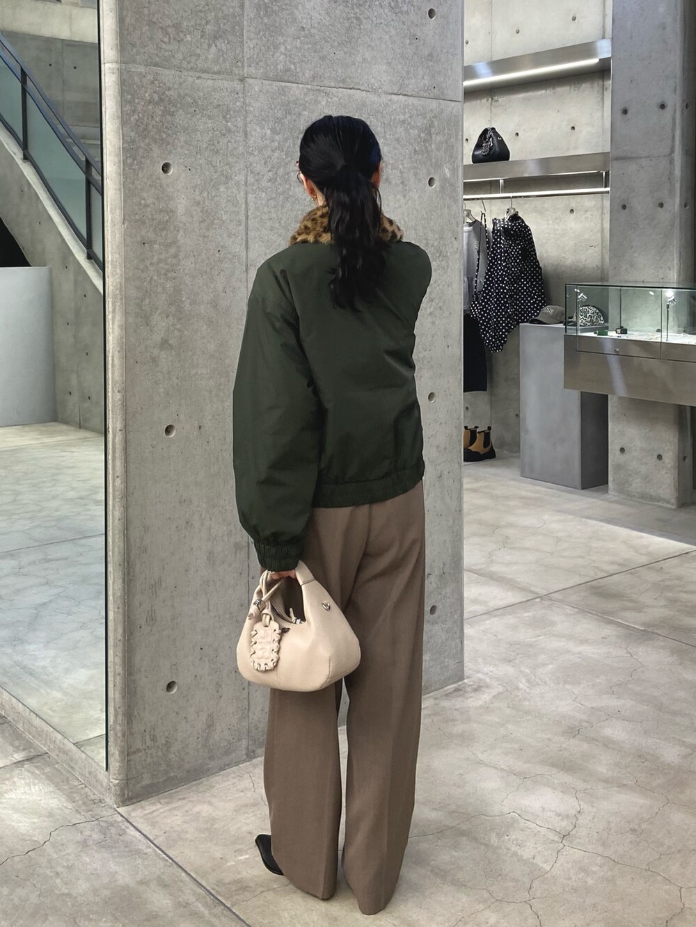 グリーン系のその他アウター、ベージュ系のその他パンツ、ホワイト系のハンドバッグを着用したレディースの冬コーディネートの3枚目の写真