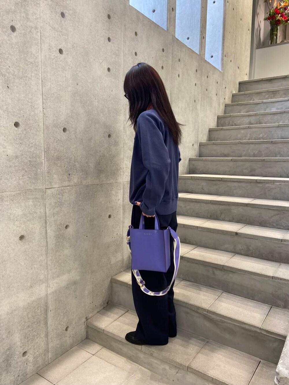 ブルー系のその他パンツ、ブルー系のスウェット、パープル系のハンドバッグを着用したレディースの冬コーディネートの4枚目の写真