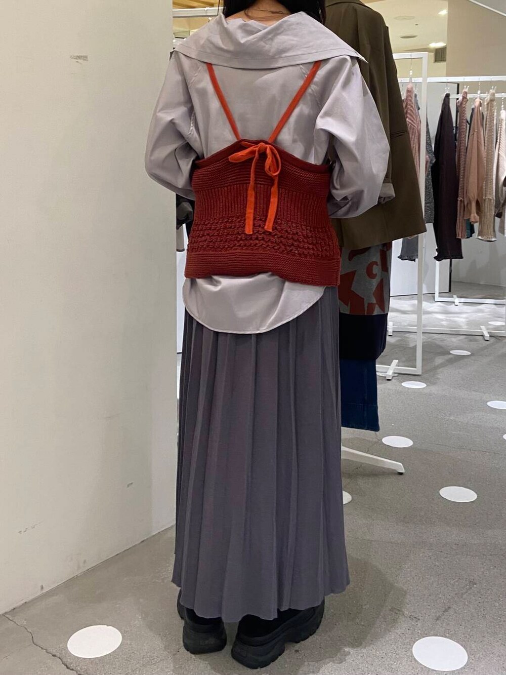 ブラウン系のニット/セーター、グレー系のTシャツ/カットソー、グレー系のスカートを着用したレディースの秋コーディネートの4枚目の写真