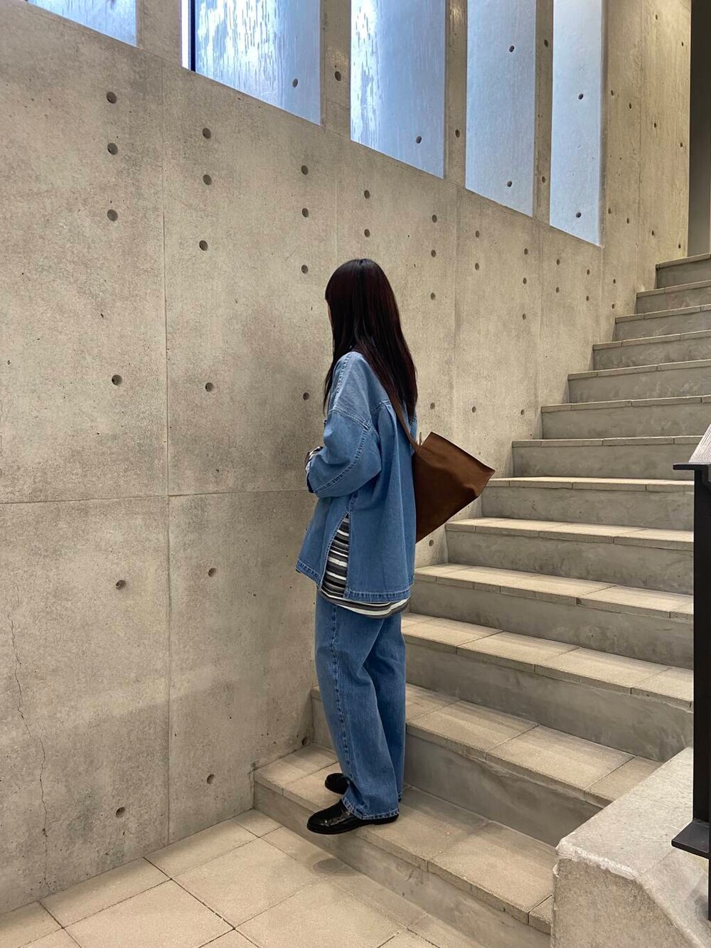 ブルー系のデニムパンツ、ブルー系のシャツ/ブラウス、ブラック系のローファーを着用したレディースの冬コーディネートの2枚目の写真