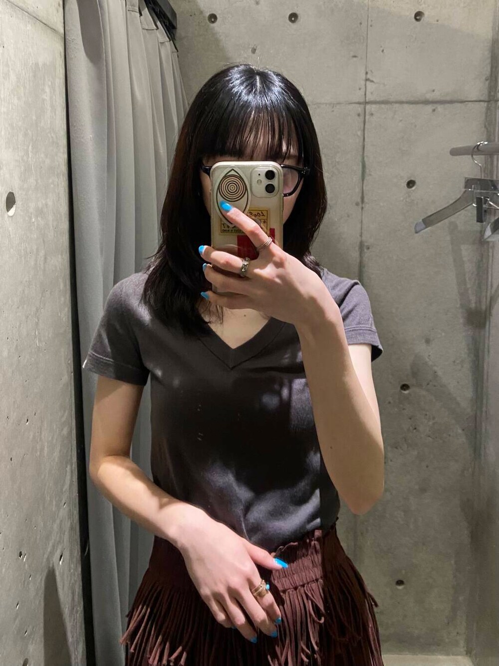 ブラウン系のスカート、ブラック系のサンダル、ブラック系のメガネを着用したレディースの春コーディネートの3枚目の写真