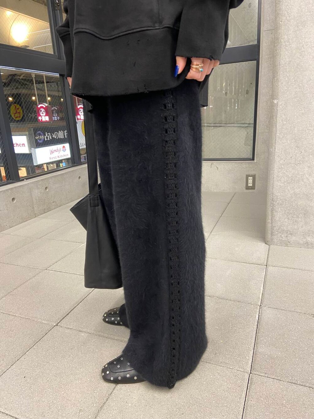 ブラック系のスウェット、ゴールド系のメガネを着用したレディースの冬コーディネートの5枚目の写真