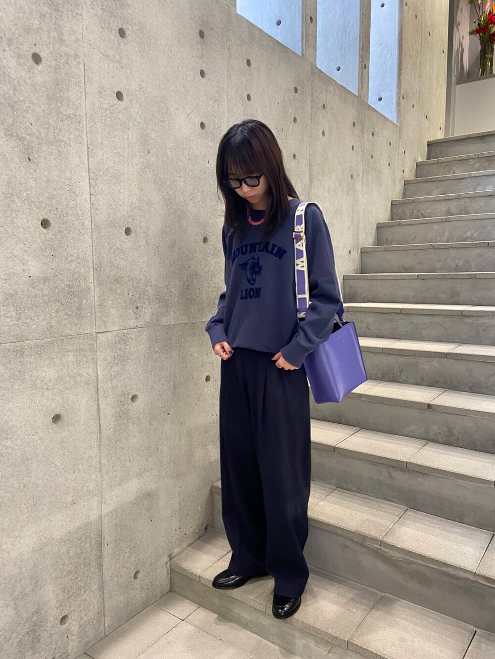 ブルー系のその他パンツ、ブルー系のスウェット、パープル系のハンドバッグを着用したレディースの冬コーディネートの2枚目の写真