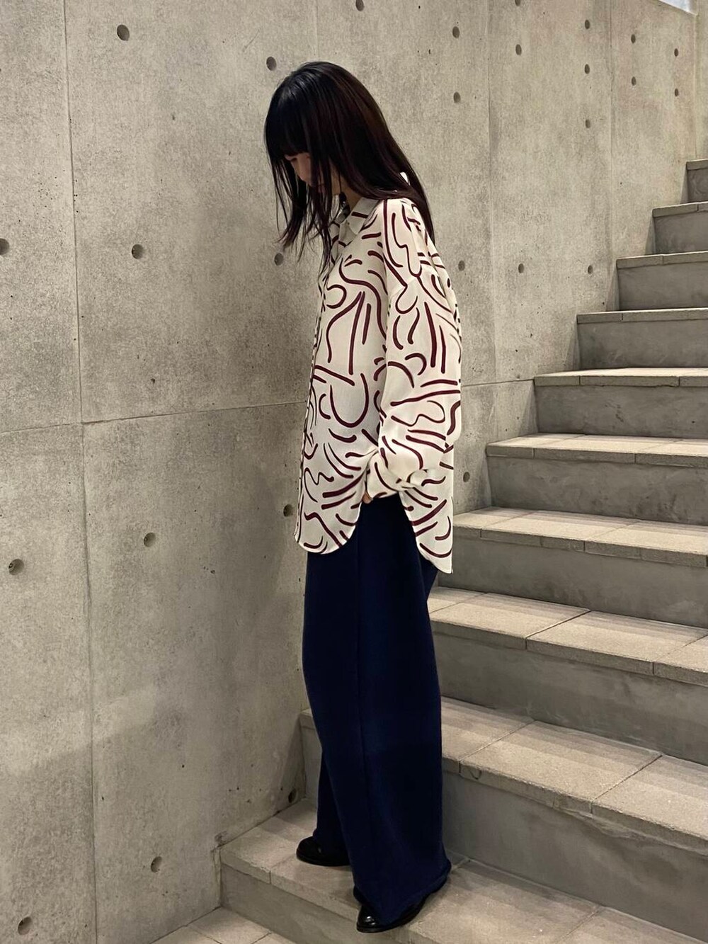 レッド系のシャツ/ブラウス、ブラック系のローファー、ブルー系のスウェットパンツを着用したレディースの冬コーディネートの3枚目の写真