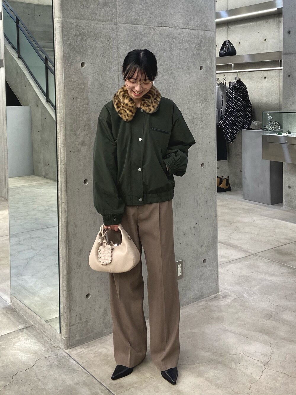 グリーン系のその他アウター、ベージュ系のその他パンツ、ホワイト系のハンドバッグを着用したレディースの冬コーディネートの4枚目の写真