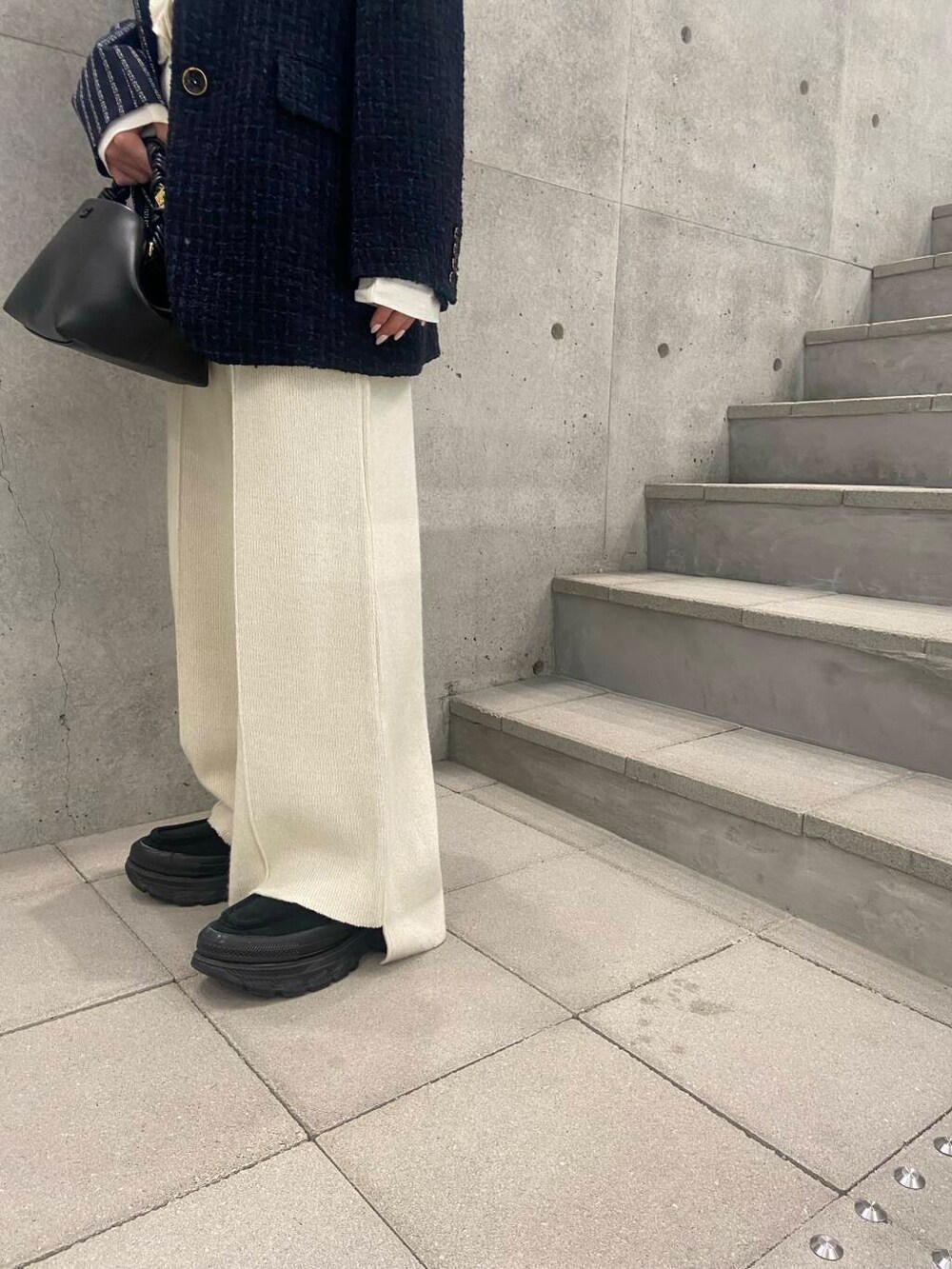 ブラック系のハンドバッグ、ホワイト系のTシャツ/カットソー、グレー系のテーラードジャケットを着用したレディースの秋コーディネートの6枚目の写真