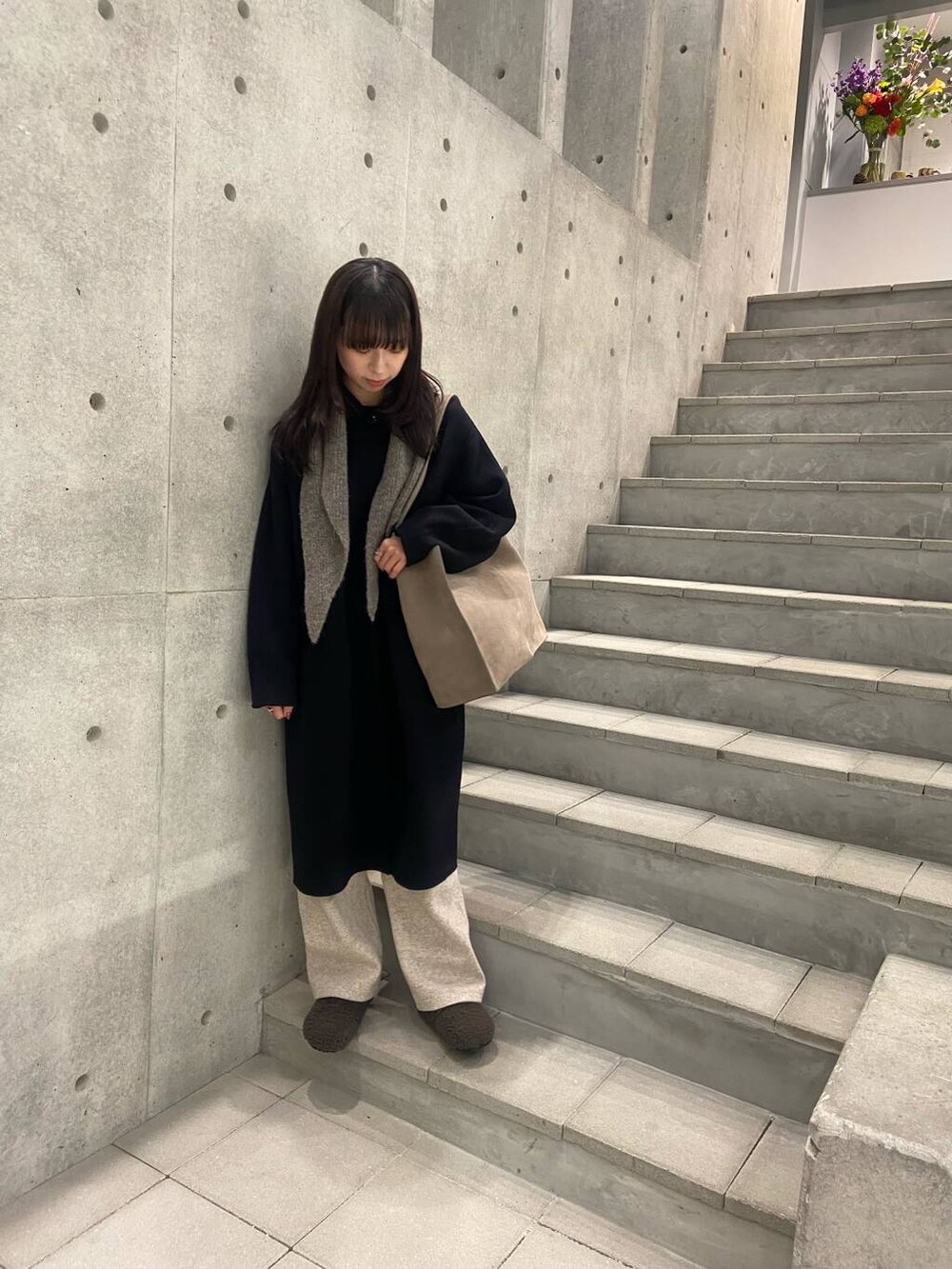 ブラック系のステンカラーコート、グレー系のサンダル、ベージュ系のその他パンツを着用したレディースの冬コーディネートの3枚目の写真