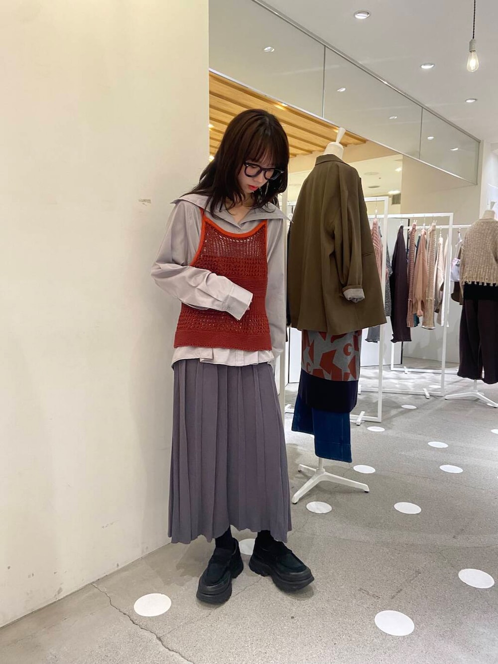 ブラウン系のニット/セーター、グレー系のTシャツ/カットソー、グレー系のスカートを着用したレディースの秋コーディネートの2枚目の写真