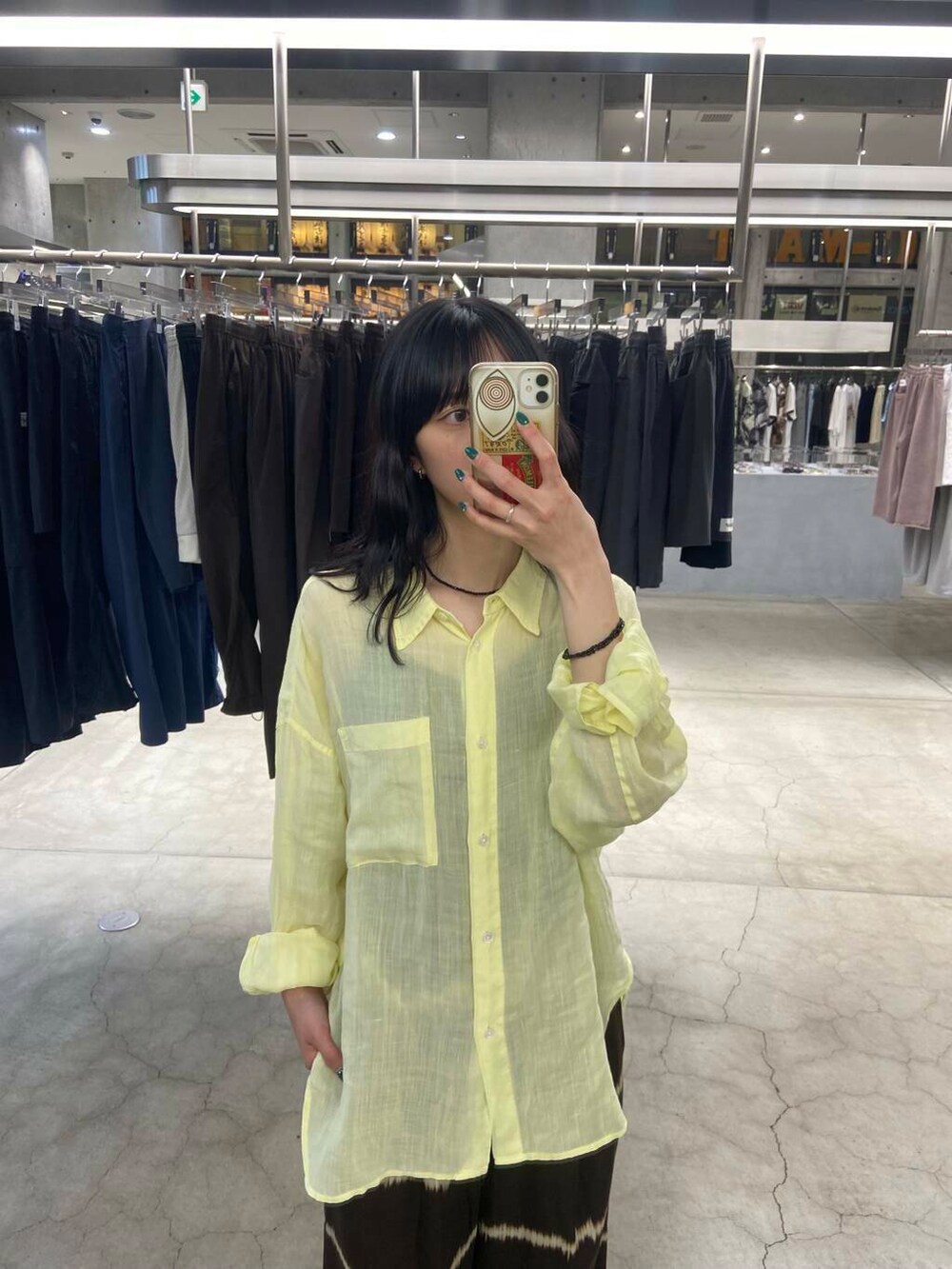 ブラック系のトートバッグ、ブラウン系のその他パンツ、イエロー系のシャツ/ブラウスを着用したレディースの夏コーディネートの4枚目の写真