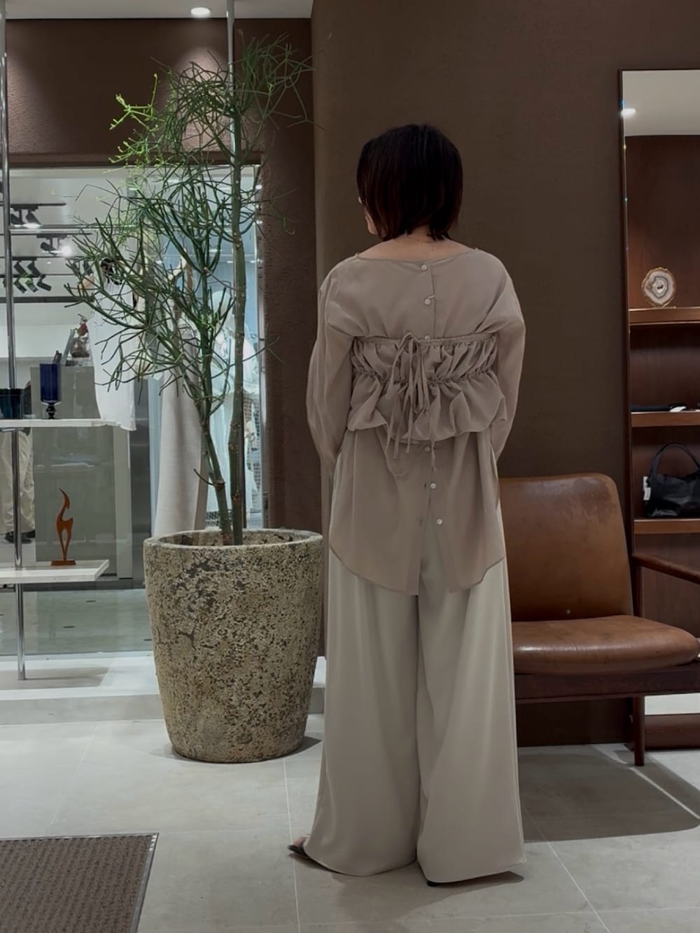 ベージュ系のシャツ/ブラウス、ベージュ系のその他パンツ、ゴールド系のチョーカーを着用したレディースの春コーディネートの3枚目の写真