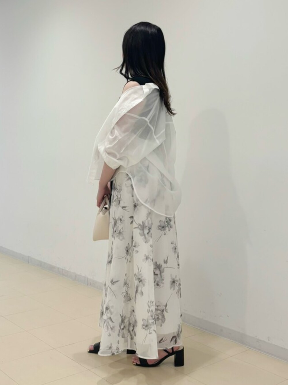 ホワイト系のワンピース、ブラック系のサンダル、ホワイト系のシャツ/ブラウスを着用したレディースの春コーディネートの2枚目の写真