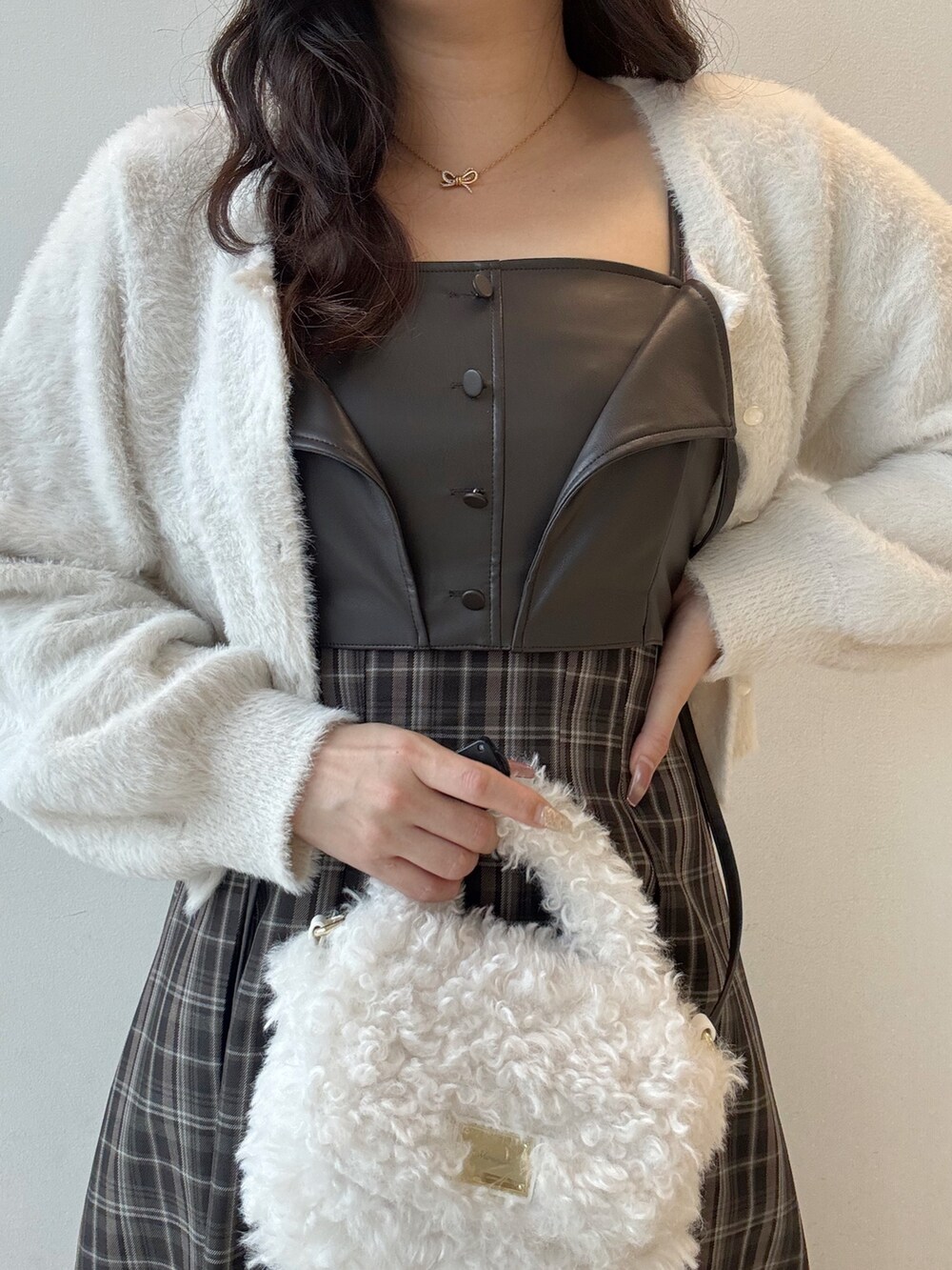 ブラウン系のワンピース、ホワイト系のカーディガン/ボレロ、ホワイト系のハンドバッグを着用したレディースの秋コーディネートの4枚目の写真