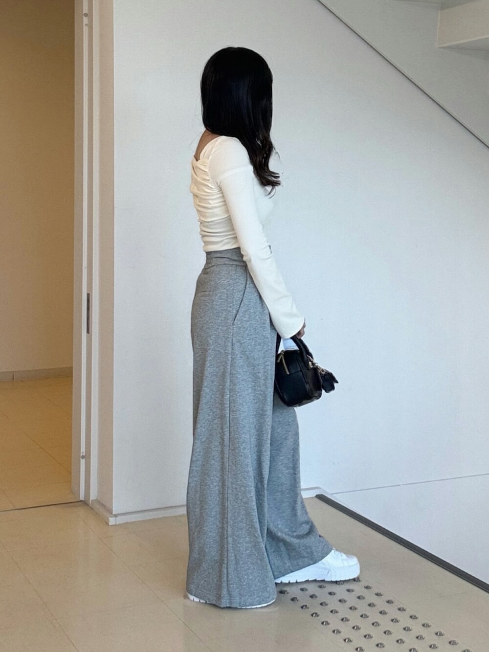 ホワイト系のTシャツ/カットソー、グレー系のその他パンツ、ホワイト系のスニーカーを着用したレディースの秋コーディネートの3枚目の写真