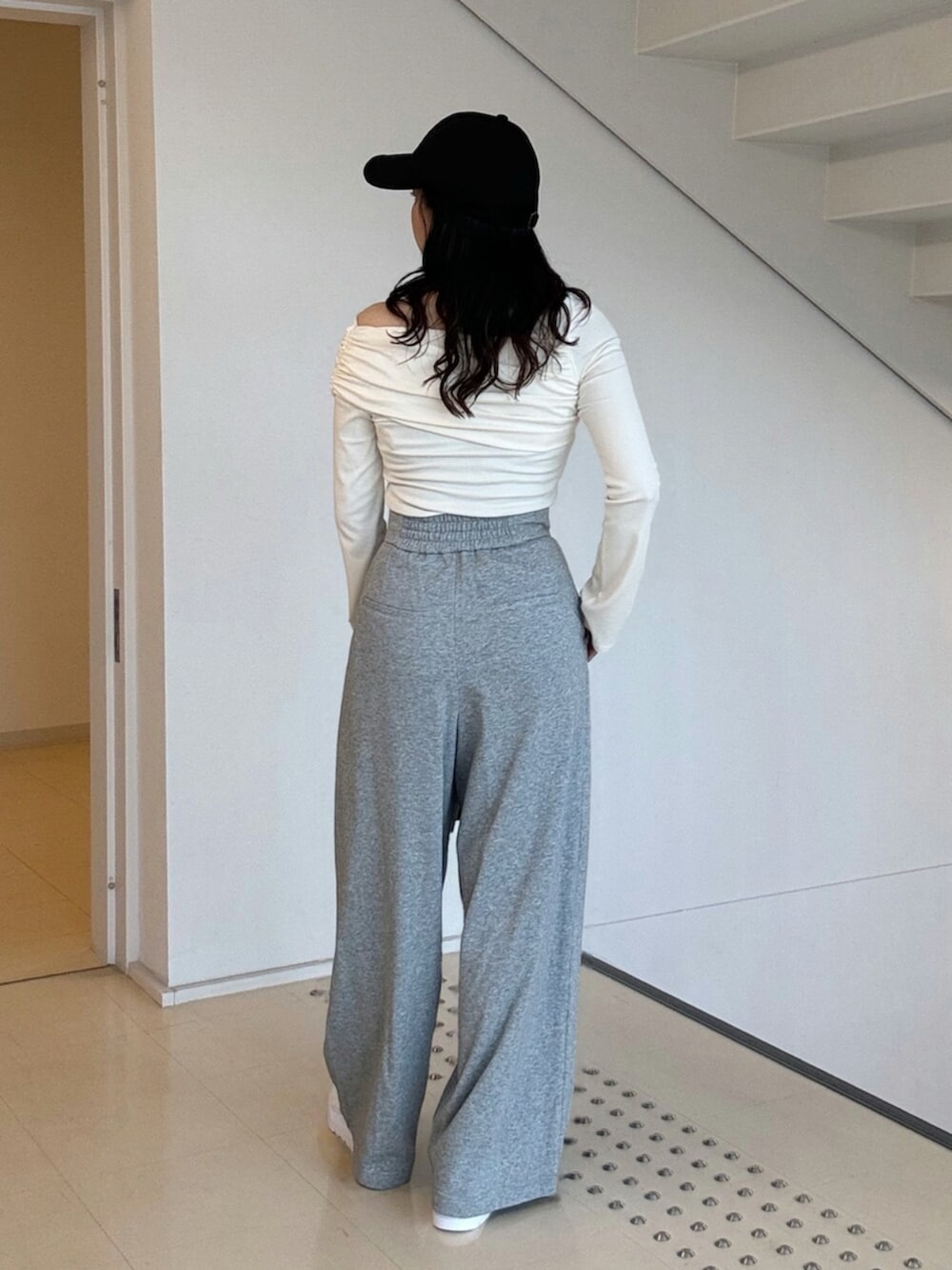 ホワイト系のTシャツ/カットソー、グレー系のその他パンツ、ホワイト系のスニーカーを着用したレディースの秋コーディネートの2枚目の写真