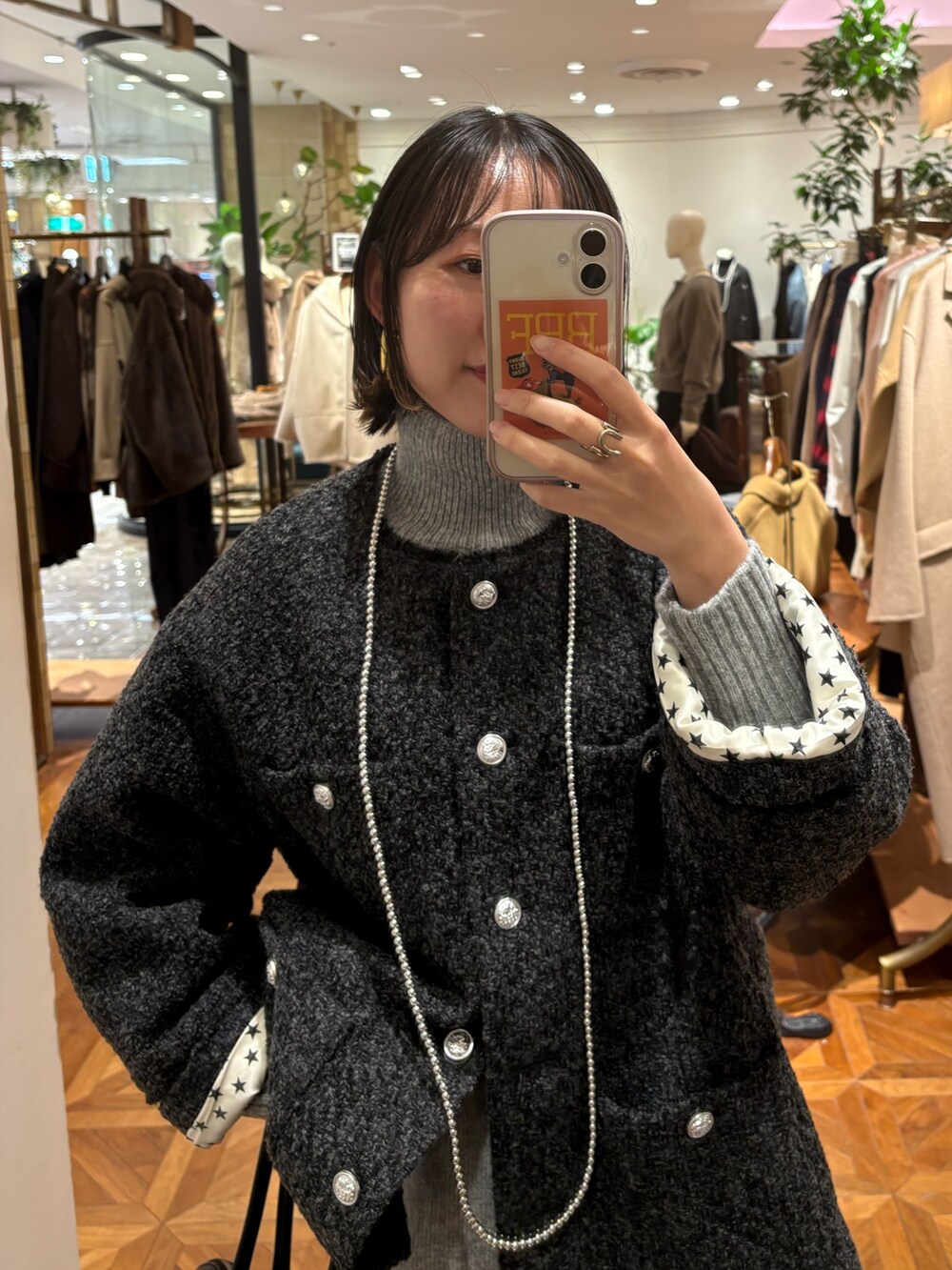 グレー系のノーカラージャケット、グレー系のワンピース、ブラック系のバッグを着用したレディースの秋コーディネートの3枚目の写真