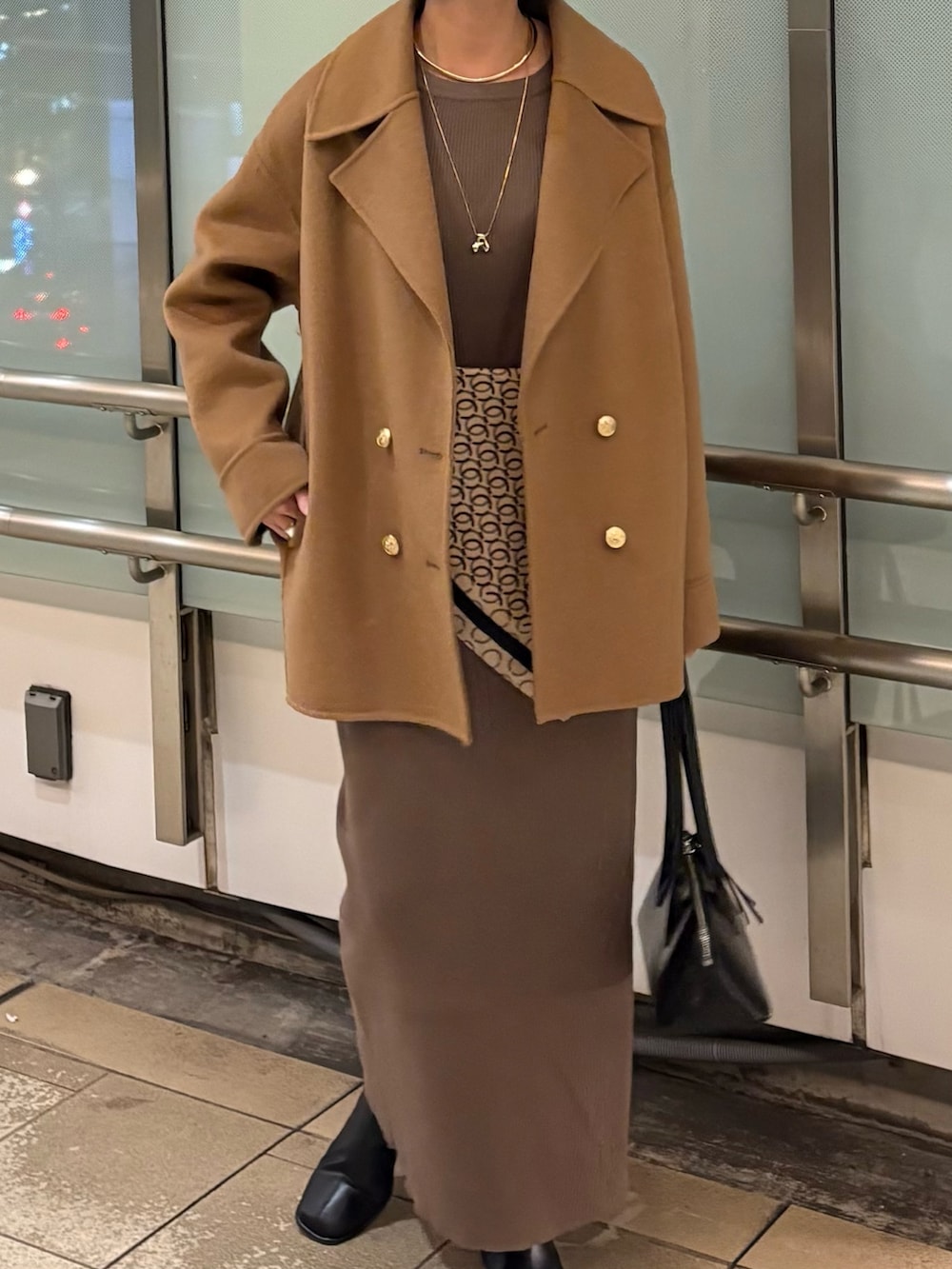ブラウン系のワンピース、イエロー系のジャケット/アウター、ブラック系のバッグを着用したレディースの冬コーディネートの4枚目の写真