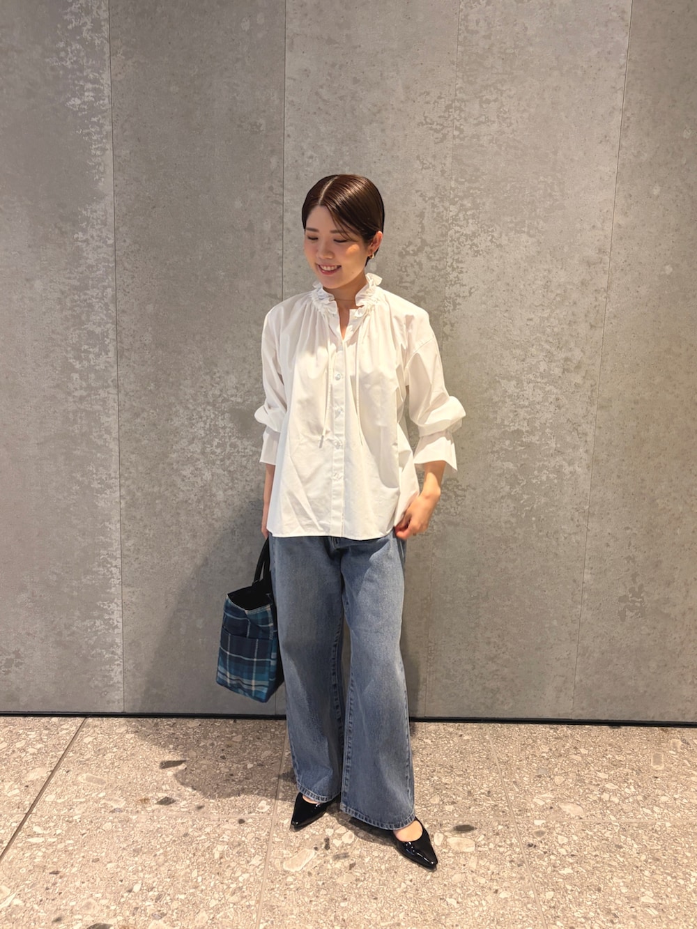 ブルー系のデニムパンツ、ブルー系のトートバッグ、ブラック系のパンプスを着用したレディースの夏コーディネートの2枚目の写真