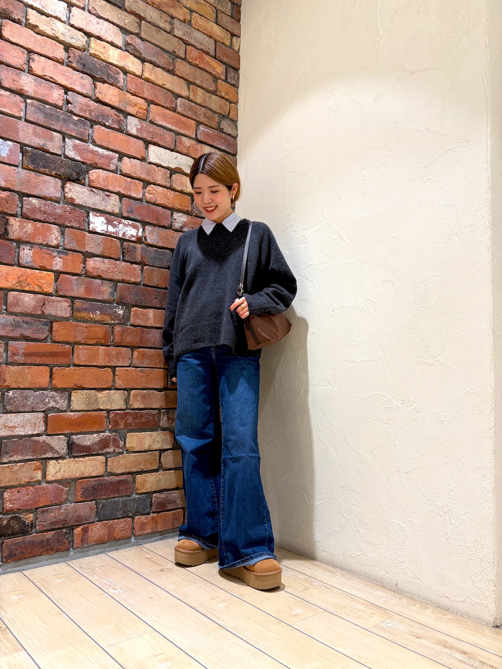 グレー系のニット/セーター、ベージュ系のダウンジャケット/コート、ブルー系のシャツ/ブラウスを着用したレディースの冬コーディネートの4枚目の写真