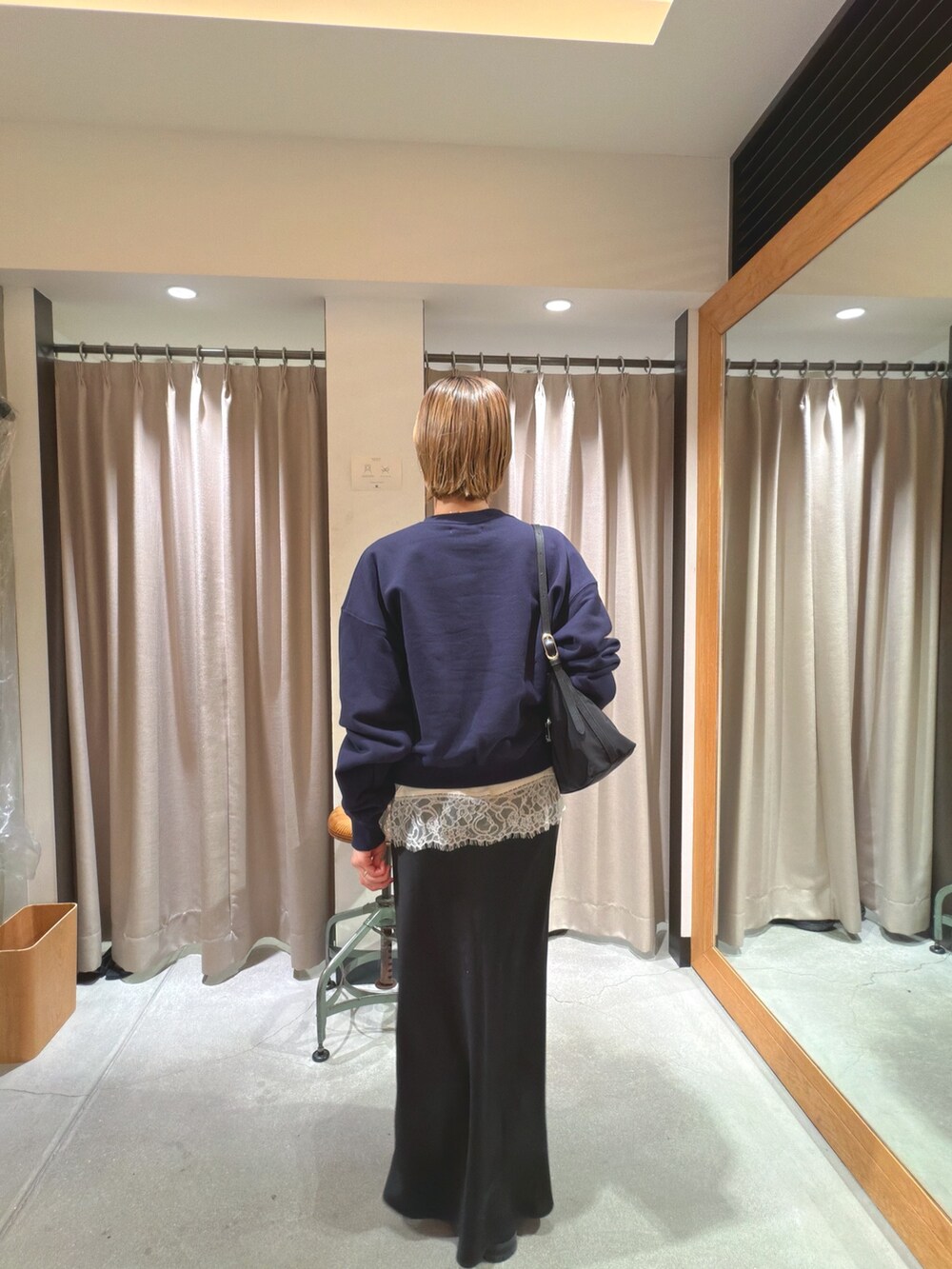 ブルー系のスウェット、ホワイト系のキャミソール、ブラック系のショルダーバッグを着用したレディースの冬コーディネートの3枚目の写真