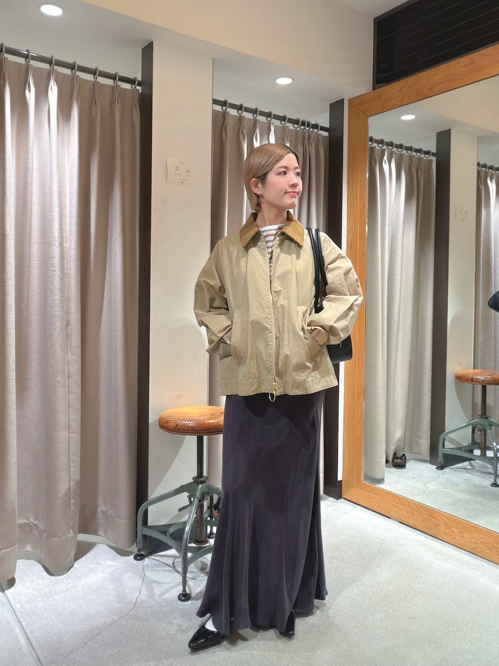 ベージュ系のその他アウター、ホワイト系のTシャツ/カットソー、グリーン系のスカートを着用したレディースの春コーディネートの2枚目の写真