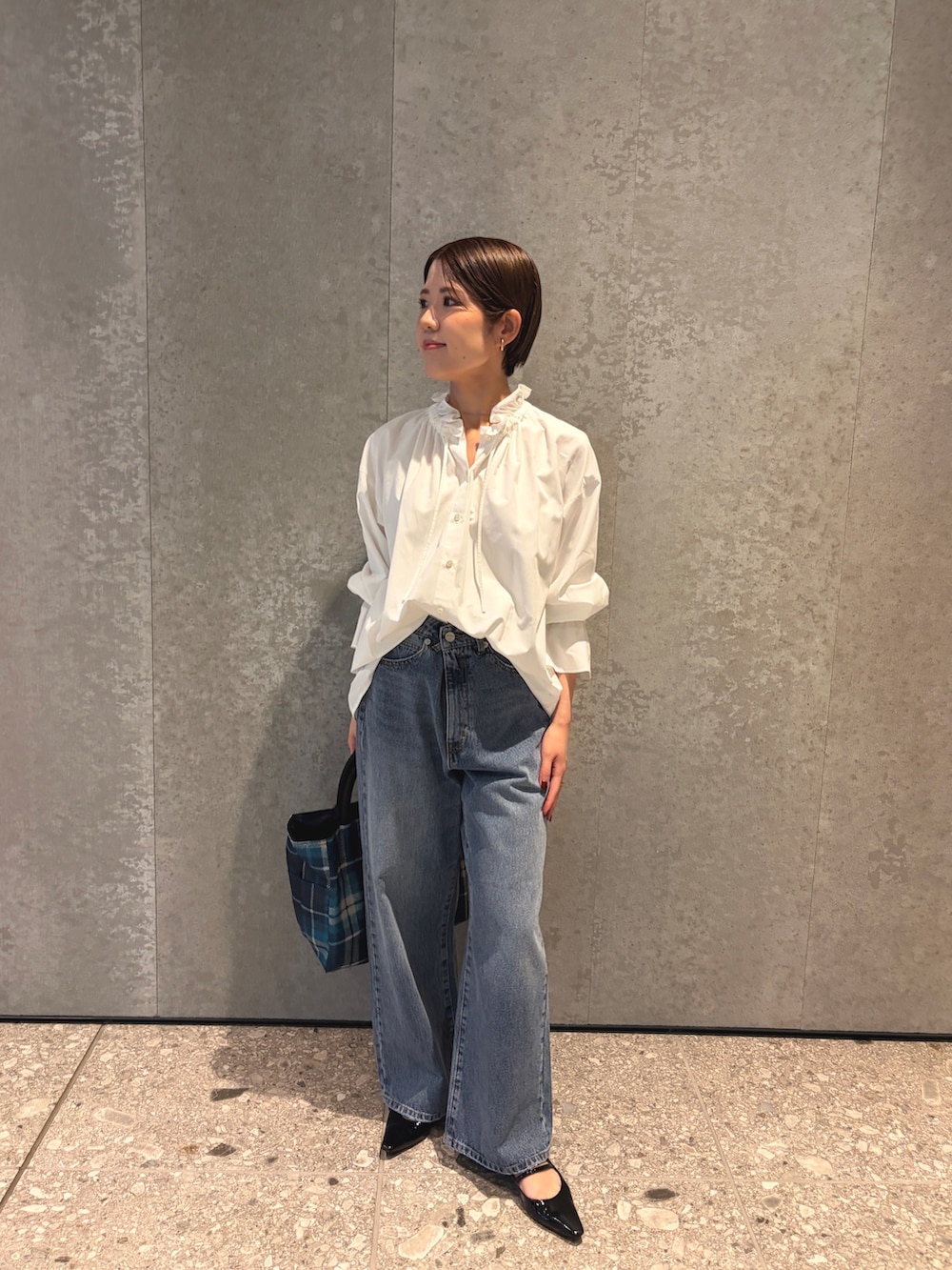 ブルー系のデニムパンツ、ブルー系のトートバッグ、ブラック系のパンプスを着用したレディースの夏コーディネートの5枚目の写真
