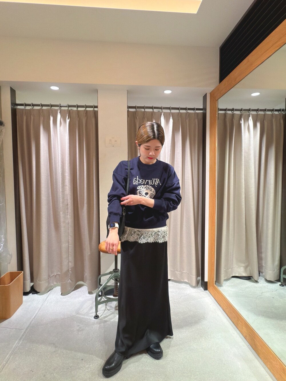 ブルー系のスウェット、ホワイト系のキャミソール、ブラック系のショルダーバッグを着用したレディースの冬コーディネートの4枚目の写真