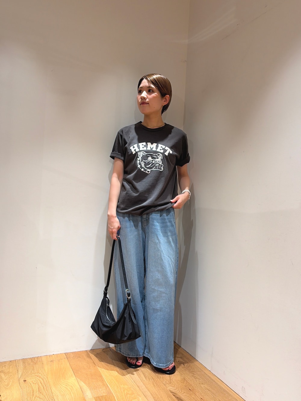 ブルー系のデニムパンツ、ブラック系のサンダル、ブラック系のTシャツ/カットソーを着用したレディースの夏コーディネートの3枚目の写真