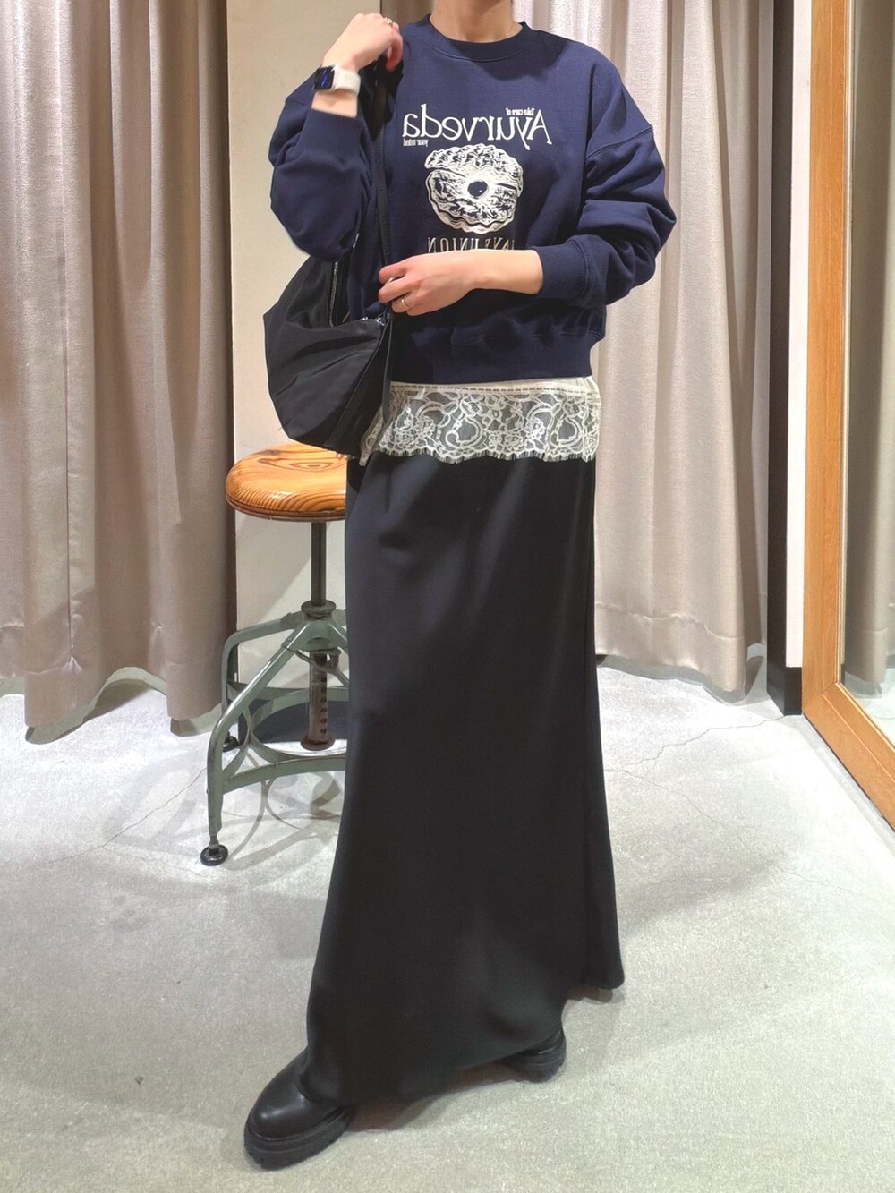 ブルー系のスウェット、ホワイト系のキャミソール、ブラック系のショルダーバッグを着用したレディースの冬コーディネートの5枚目の写真