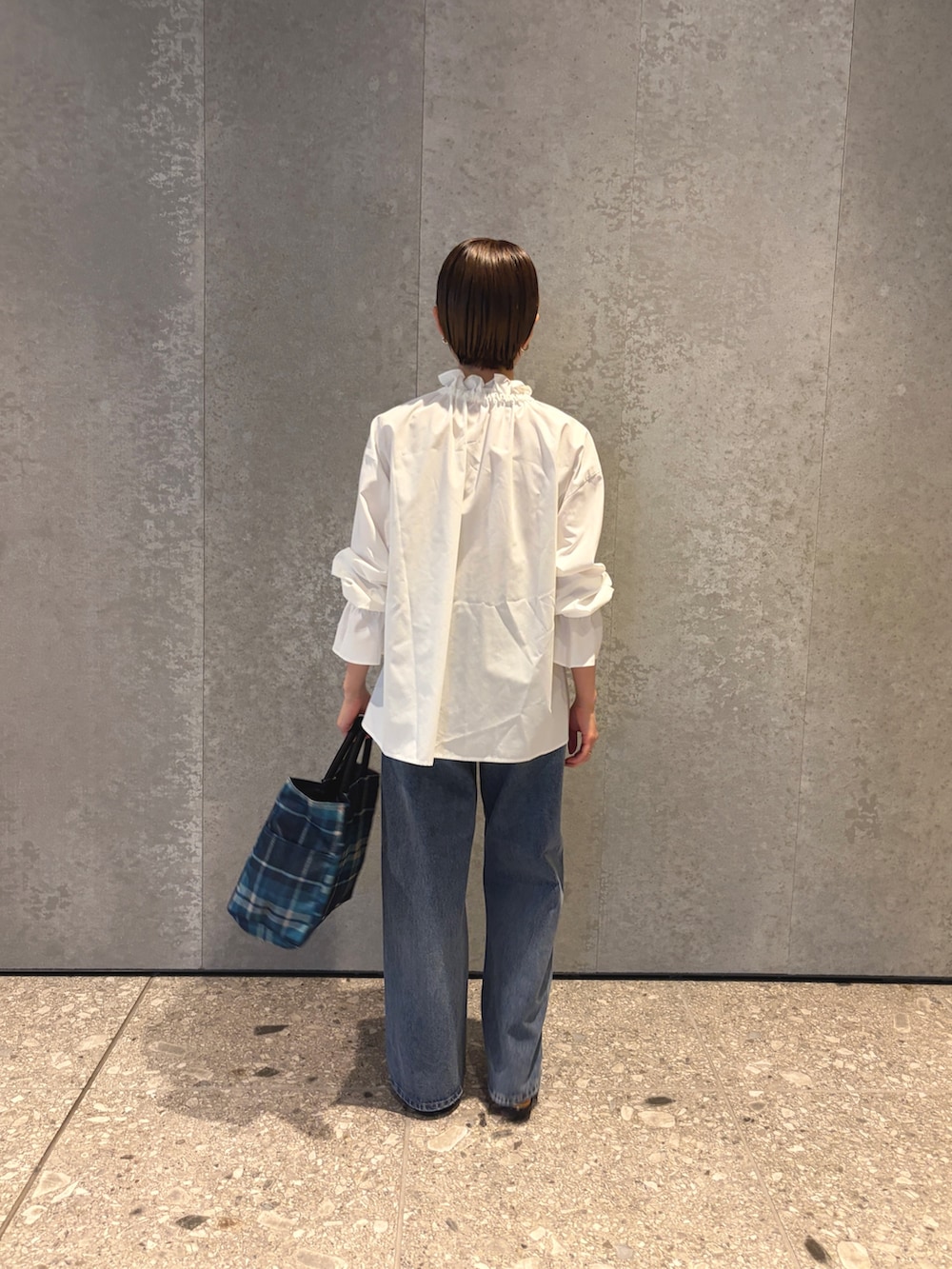 ブルー系のデニムパンツ、ブルー系のトートバッグ、ブラック系のパンプスを着用したレディースの夏コーディネートの4枚目の写真