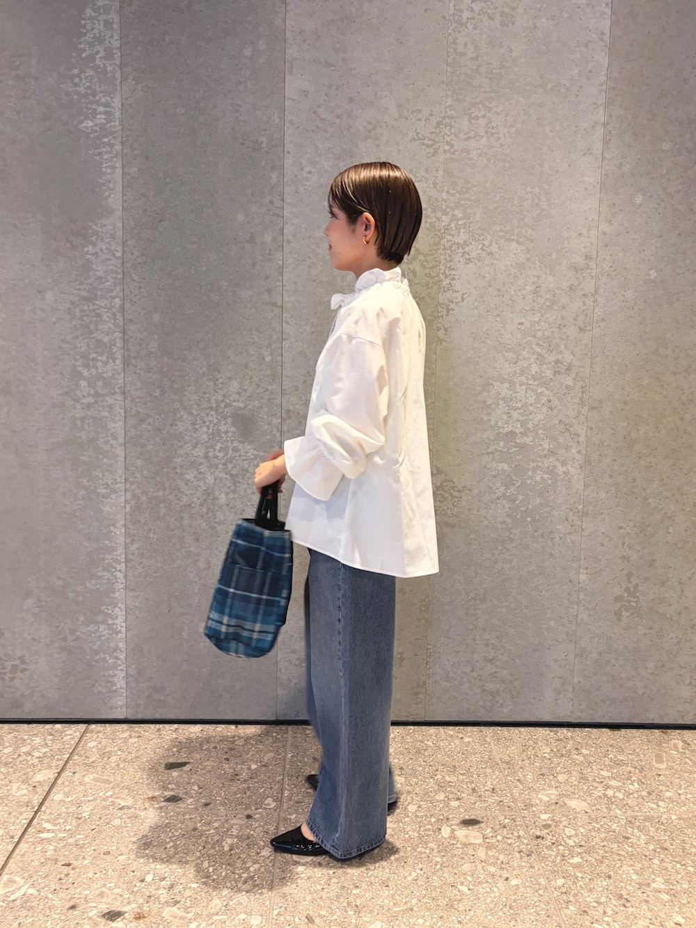 ブルー系のデニムパンツ、ブルー系のトートバッグ、ブラック系のパンプスを着用したレディースの夏コーディネートの3枚目の写真