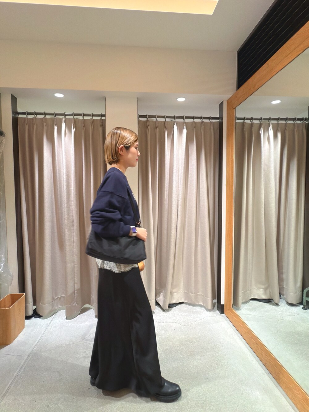 ブルー系のスウェット、ホワイト系のキャミソール、ブラック系のショルダーバッグを着用したレディースの冬コーディネートの2枚目の写真