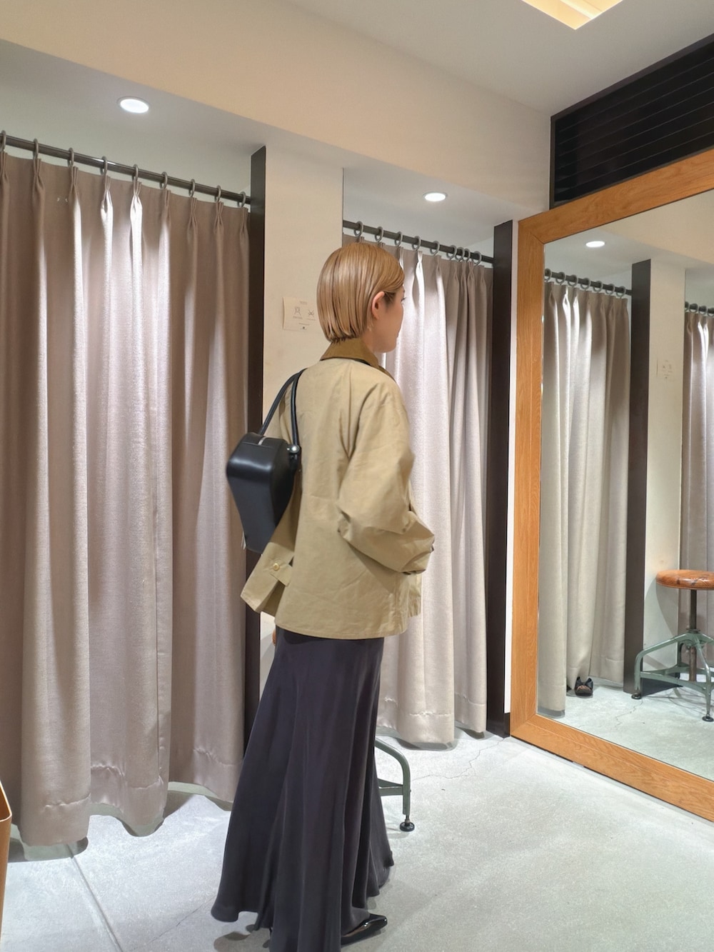 ベージュ系のその他アウター、ホワイト系のTシャツ/カットソー、グリーン系のスカートを着用したレディースの春コーディネートの3枚目の写真