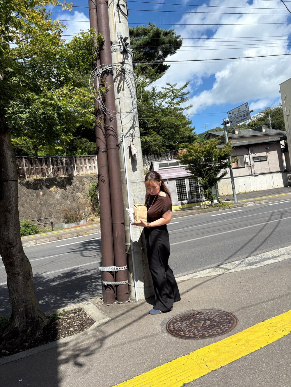 ブラック系のその他パンツ、ブラウン系のTシャツ/カットソー、ブルー系のスニーカーを着用したレディースの夏コーディネートの3枚目の写真