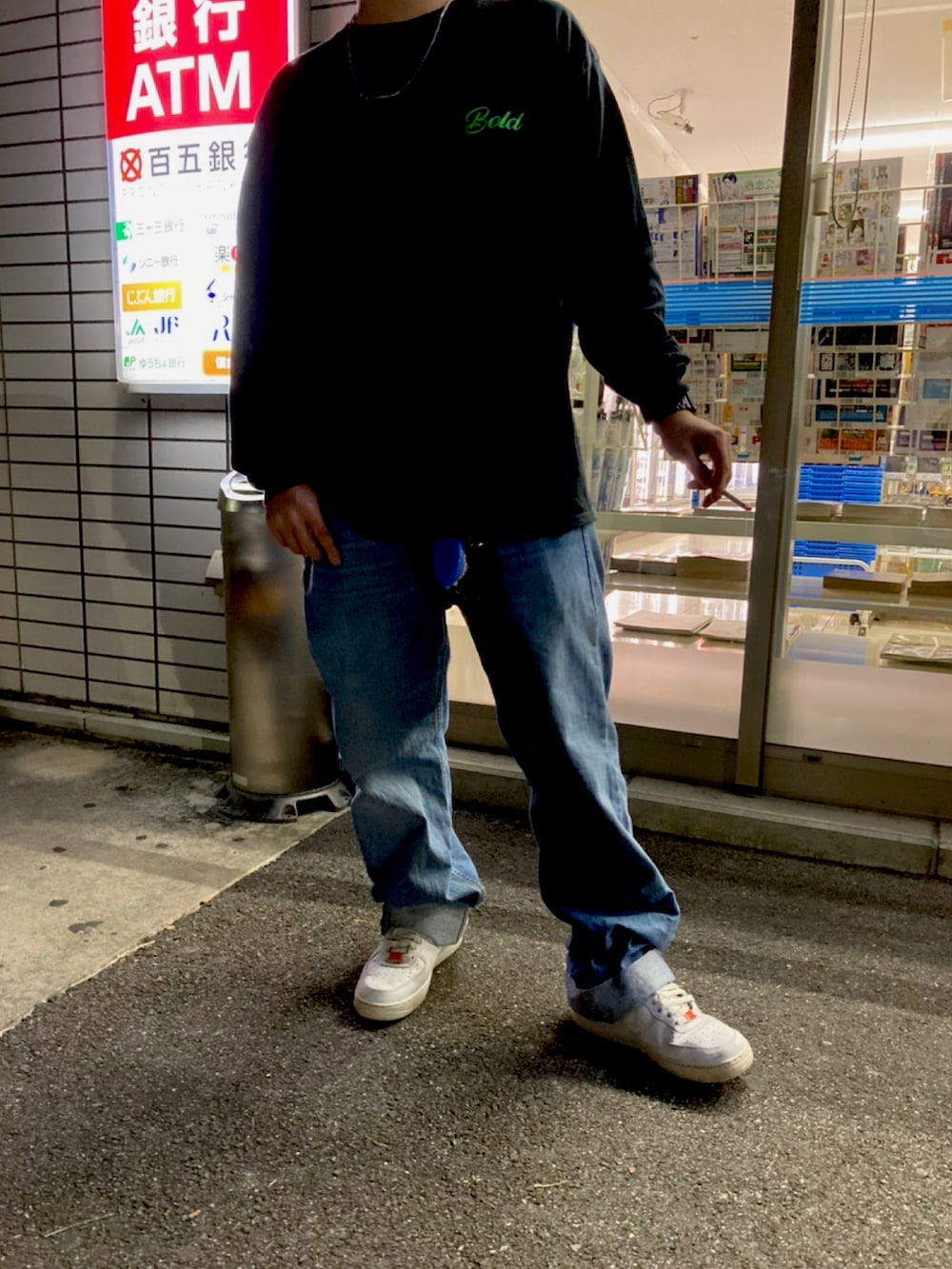 ブラック系のTシャツ/カットソー、ブルー系のデニムパンツ、ホワイト系のスニーカーを着用したメンズの秋コーディネートの2枚目の写真