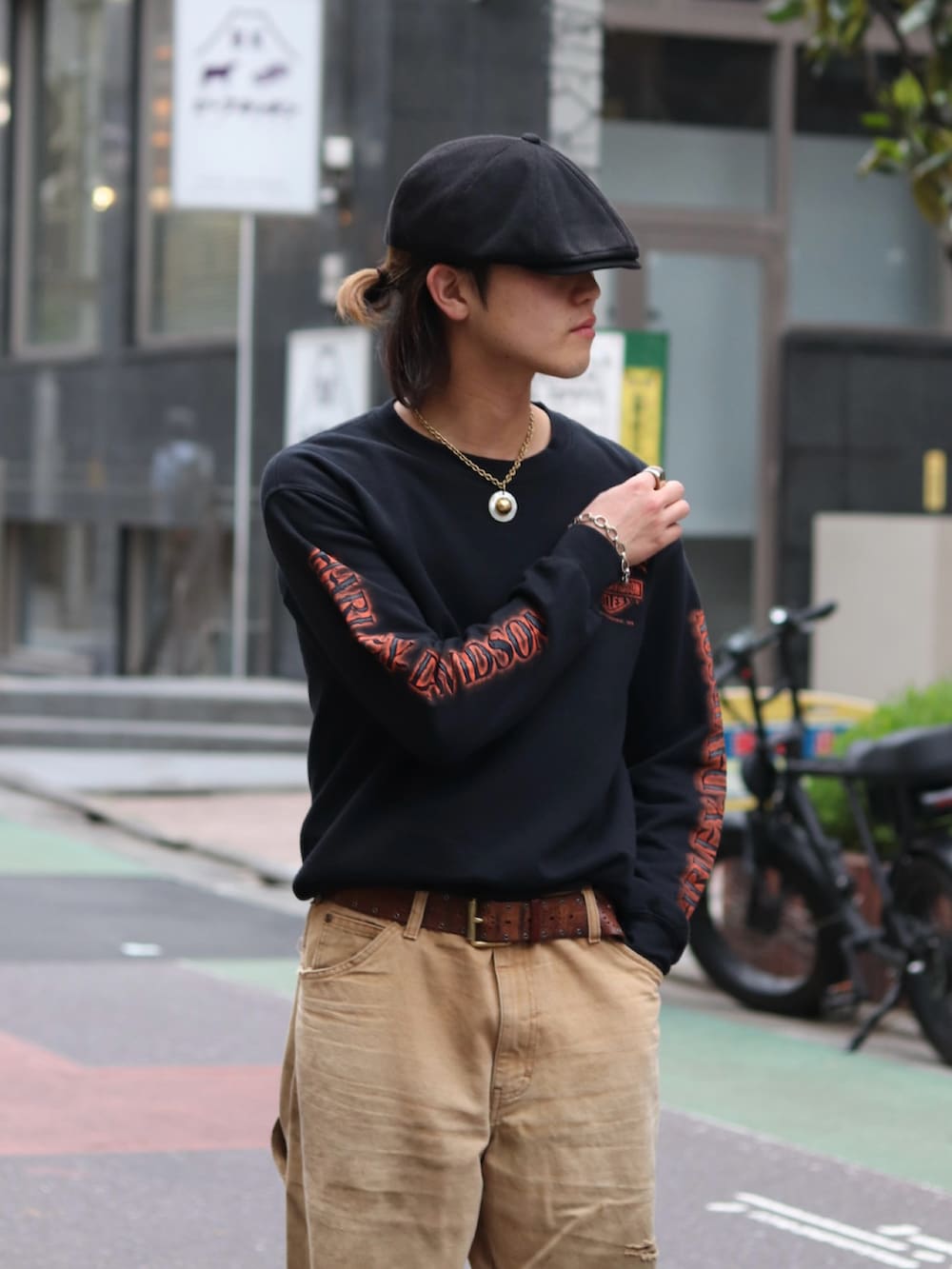 ブラック系のスウェット、ベージュ系のパンツ、ブラック系のドレスシューズを着用したメンズの春コーディネートの2枚目の写真