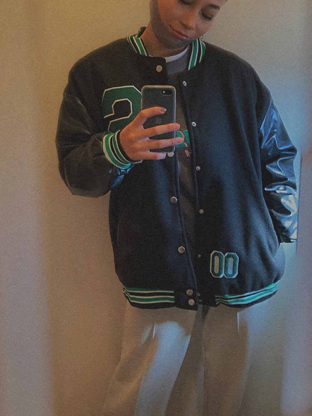 グレー系のスウェット、ブラック系のスタジャン、ベージュ系のスウェットパンツを着用したレディースの冬コーディネートの2枚目の写真