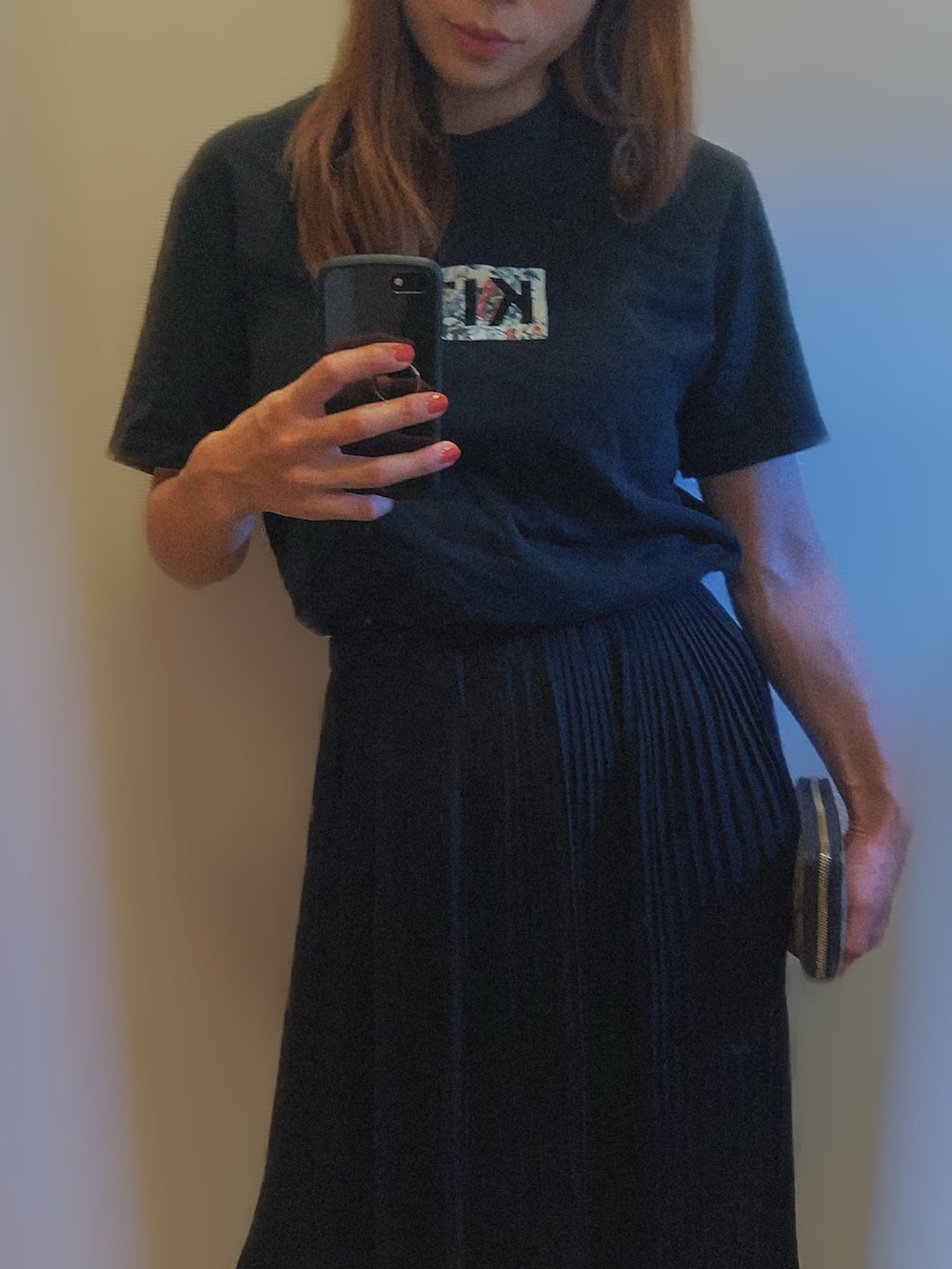 ブラック系のTシャツ/カットソー、ブラック系のスカート、ホワイト系のスニーカーを着用したレディースの夏コーディネートの2枚目の写真