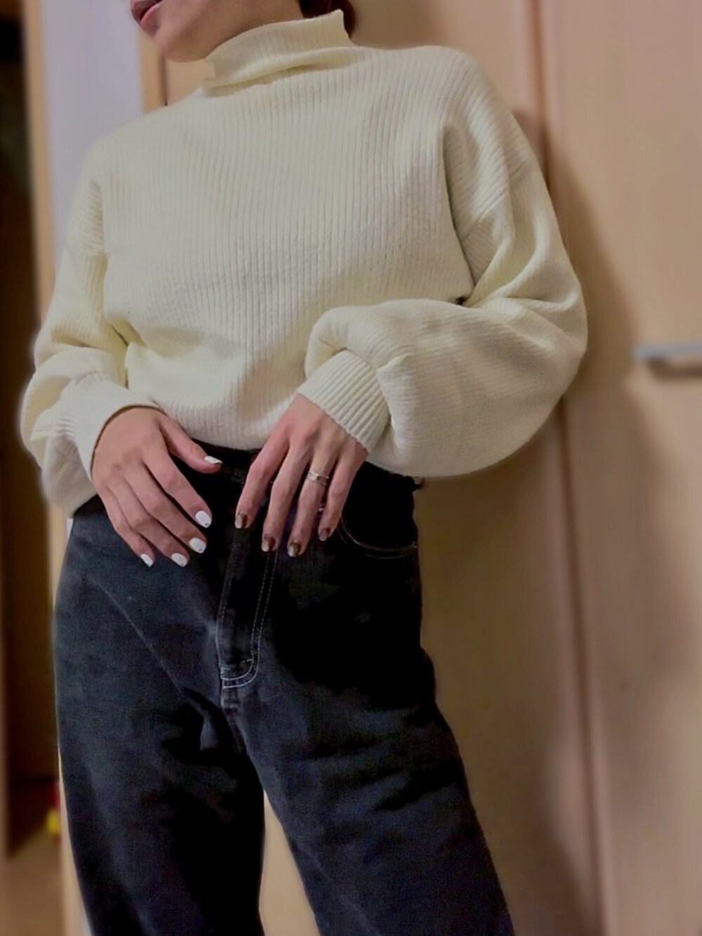 ホワイト系のニット/セーター、ブラック系のデニムパンツを着用したレディースの冬コーディネートの2枚目の写真