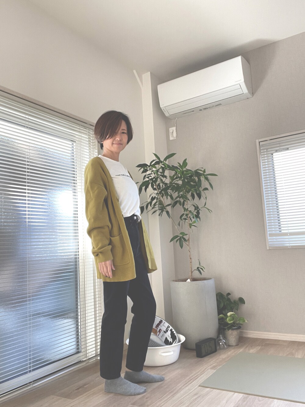 イエロー系のカーディガン/ボレロ、ホワイト系のTシャツ/カットソー、ブラック系のデニムパンツを着用したレディースの秋コーディネートの2枚目の写真