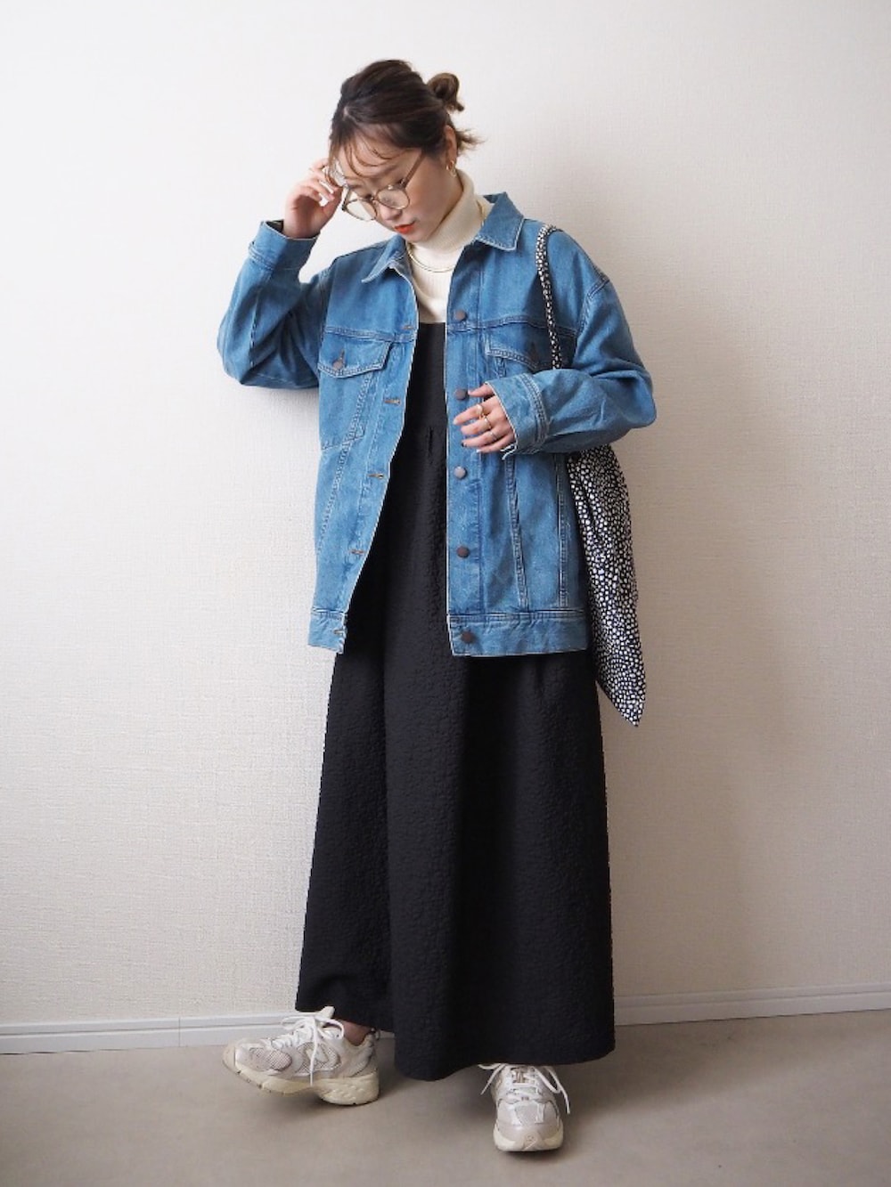 ブラック系のワンピース、ホワイト系のミリタリージャケット、ベージュ系のトートバッグを着用したレディースの冬コーディネートの2枚目の写真