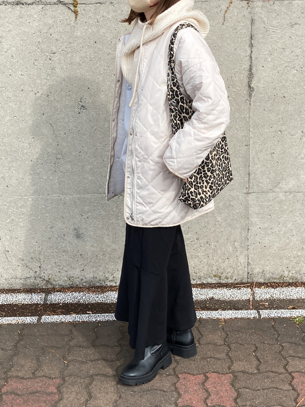 ホワイト系のノーカラージャケット、ブラック系のブーツ、ホワイト系のニットキャップ/ビーニーを着用したレディースの秋コーディネートの3枚目の写真