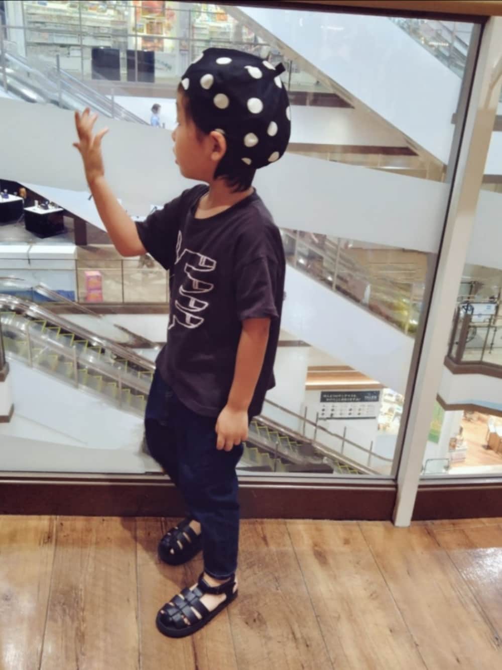 ブルー系のデニムパンツ、ブラック系のサンダル、ブラック系のTシャツ/カットソーを着用したキッズの秋コーディネートの2枚目の写真