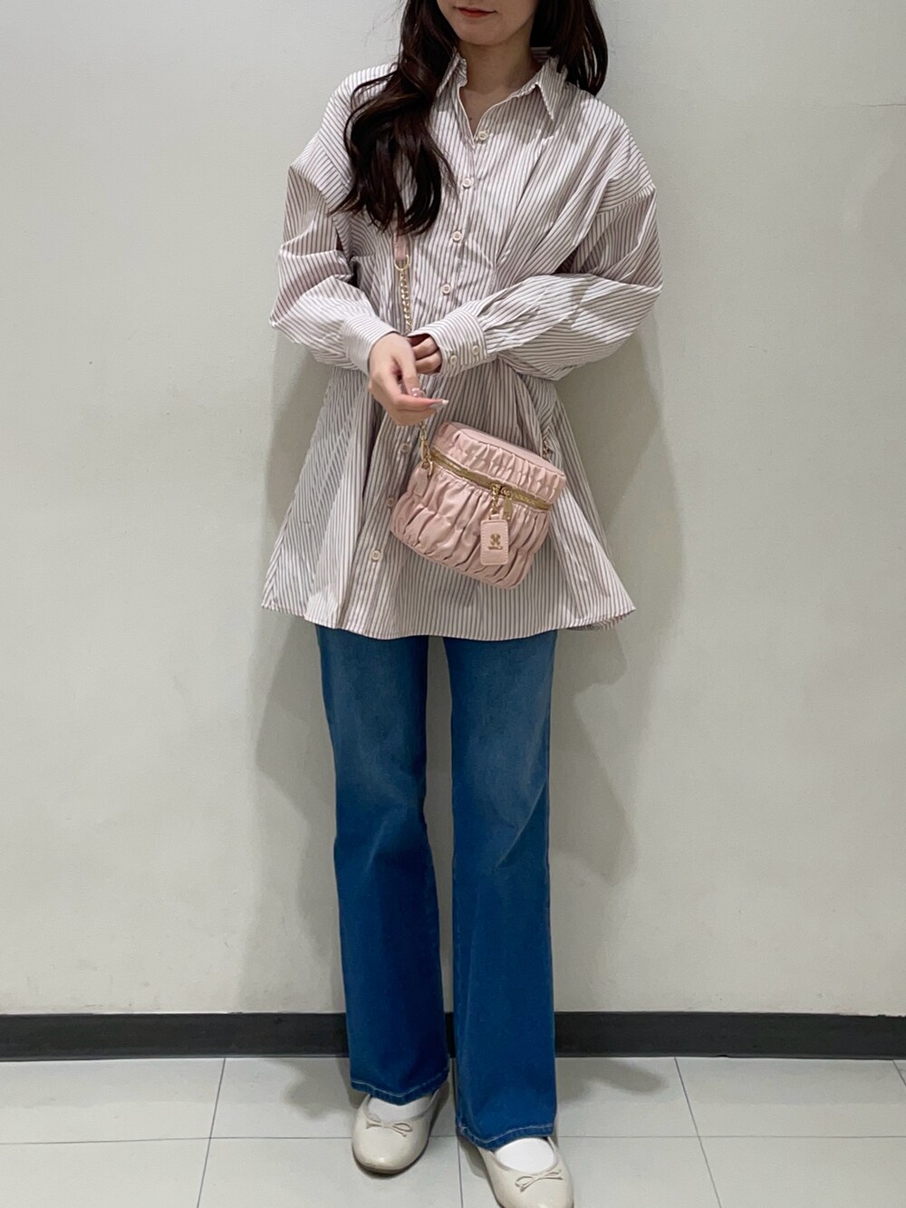 ピンク系のシャツ/ブラウス、ブルー系のデニムパンツ、ピンク系のショルダーバッグを着用したレディースの春コーディネートの4枚目の写真