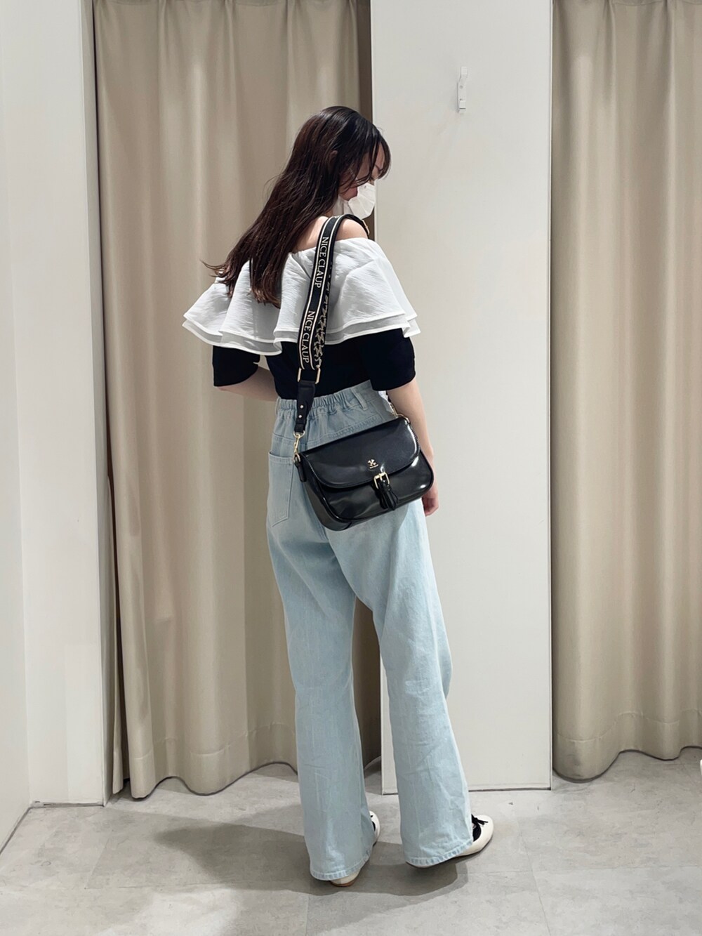 ブラック系のTシャツ/カットソー、ブルー系のデニムパンツ、ブラック系のショルダーバッグを着用したレディースの夏コーディネートの3枚目の写真