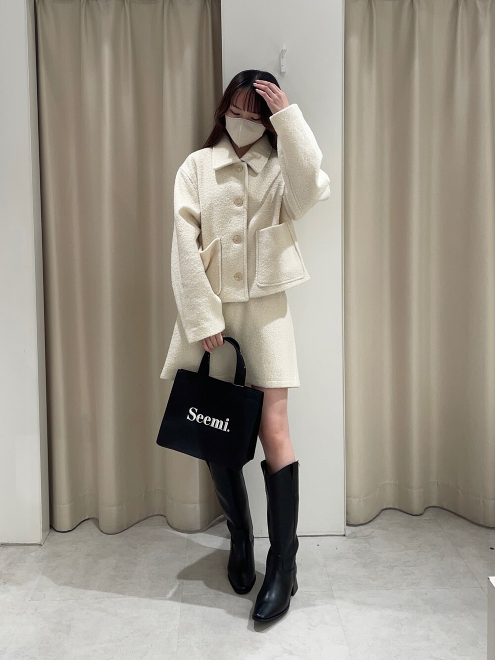 ホワイト系のその他アウター、ホワイト系のスカート、ブラック系のトートバッグを着用したレディースの夏コーディネートの2枚目の写真