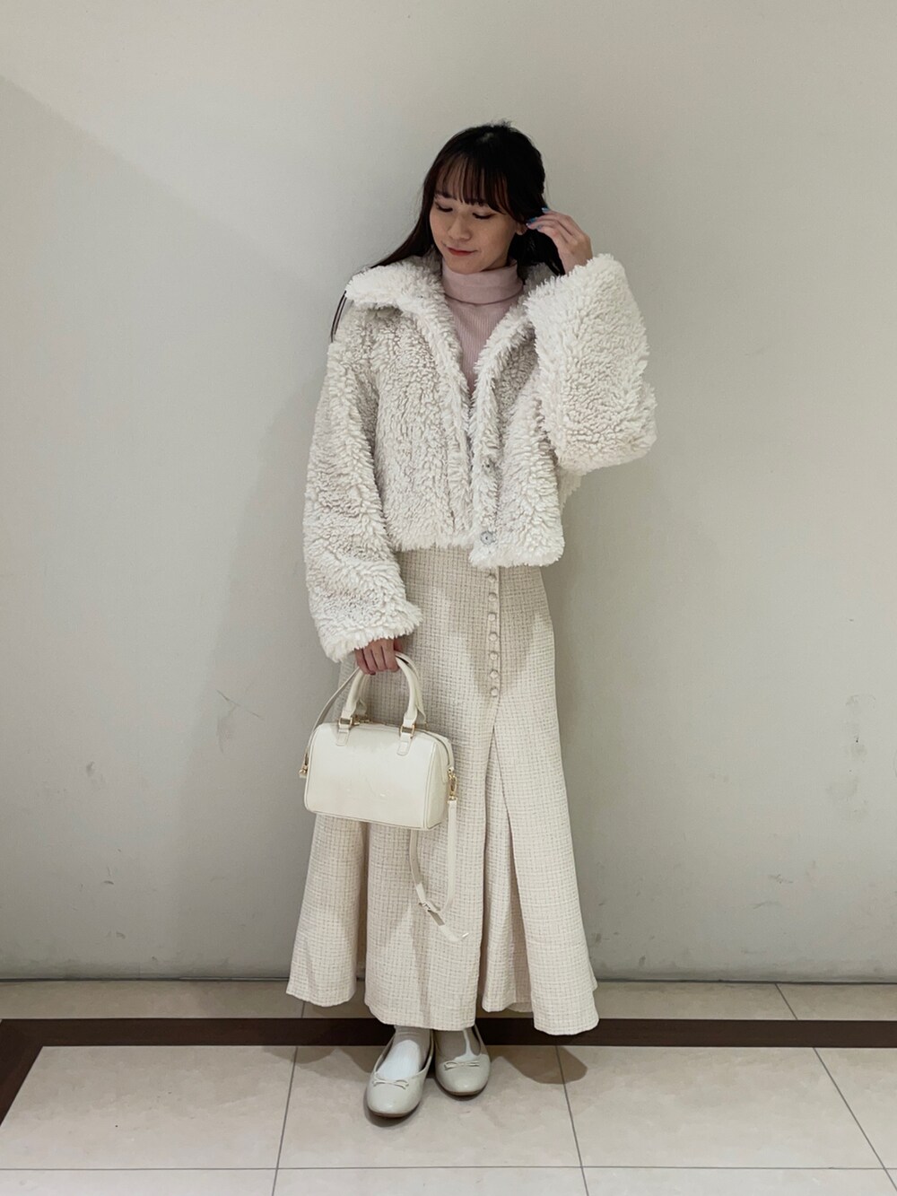 ホワイト系のブルゾン、ホワイト系のスカート、ホワイト系のハンドバッグを着用したレディースの秋コーディネートの3枚目の写真