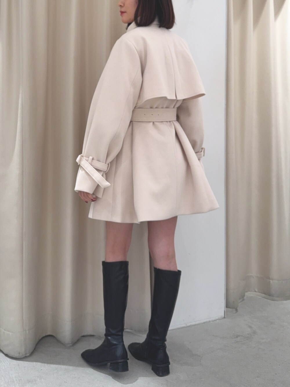 ホワイト系のチェスターコートを着用したレディースの冬コーディネートの3枚目の写真
