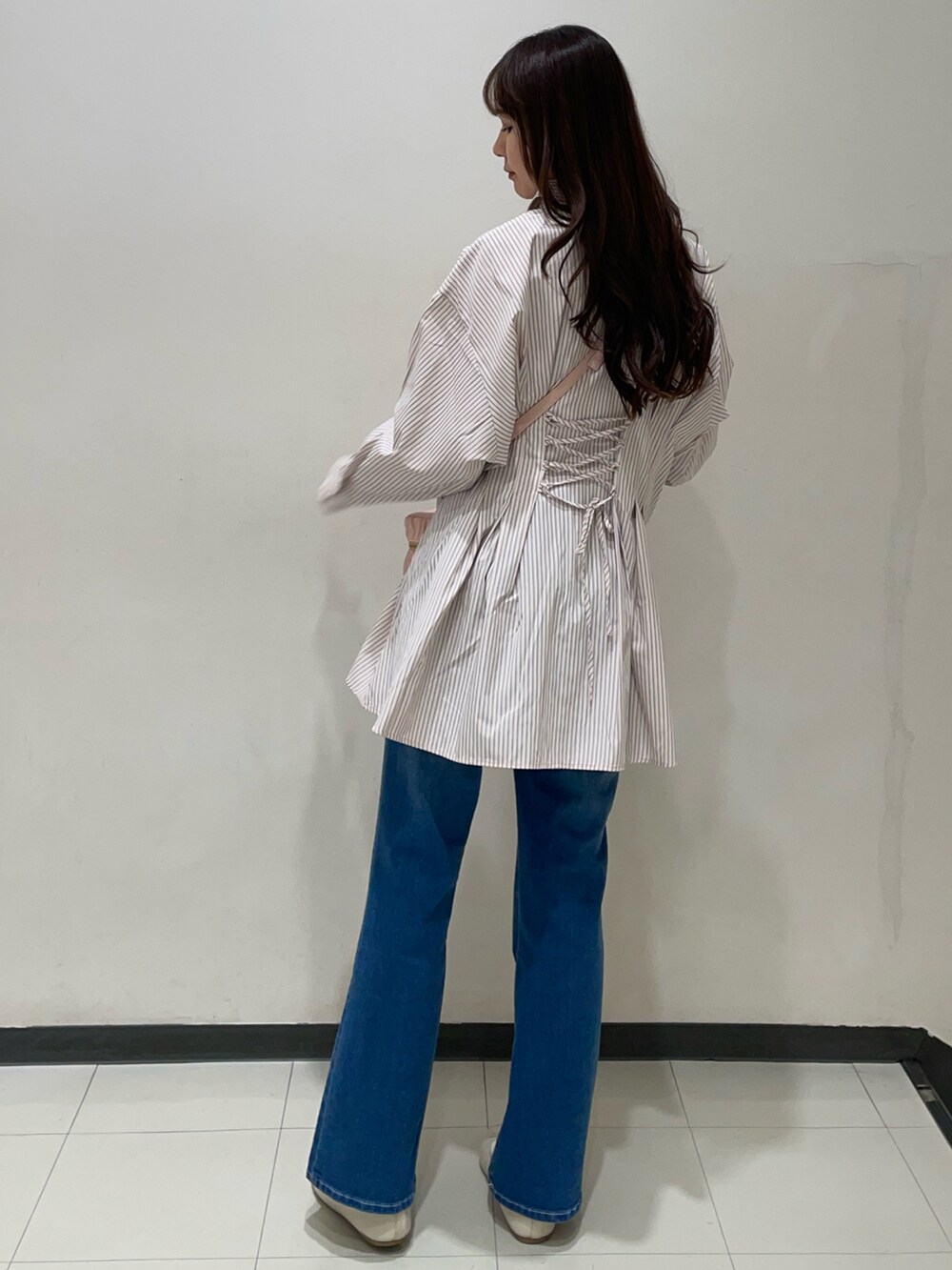 ピンク系のシャツ/ブラウス、ブルー系のデニムパンツ、ピンク系のショルダーバッグを着用したレディースの春コーディネートの3枚目の写真