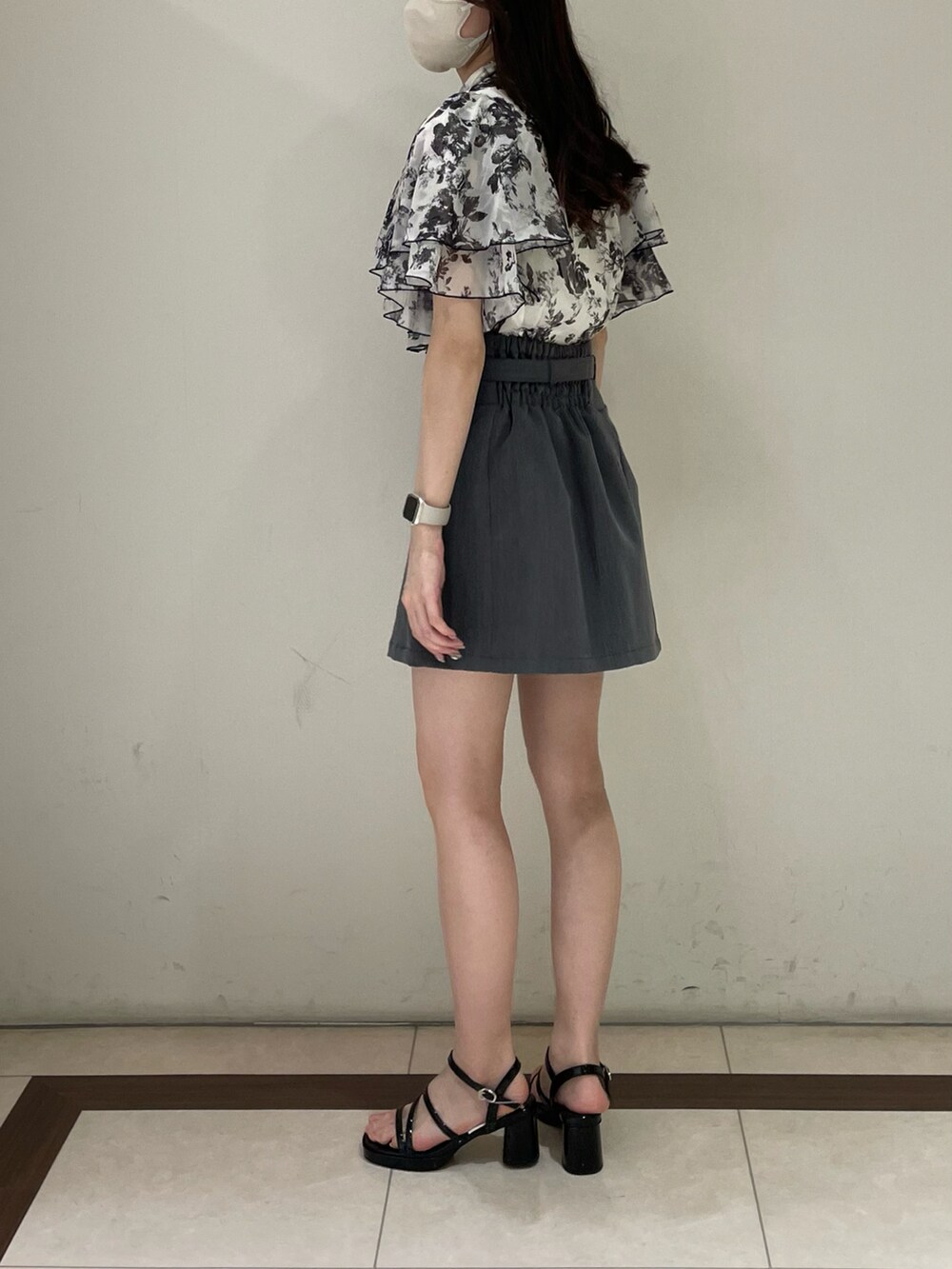 ホワイト系のシャツ/ブラウス、グレー系のスカート、ブラック系のサンダルを着用したレディースの夏コーディネートの2枚目の写真